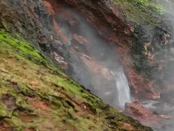 MS Shot of water flowing down and moss covered mountainside into hot spring / Reykjavik, Hofudhborgarsvaedhi, Iceland  Stock Footage
