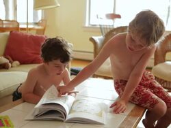 MS  Two boys looking at coloring book / WOLFEBRO, NH, USA        Stock Footage