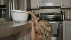 Medium shot of girl taking cookie dough from bowl in kitchen / Orem, Utah, United States Stock Footage