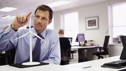 Businessman contemplating wind turbine model Stock Footage