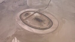 A vast, dry lake bed surrounds an abandoned racetrack in Ivanpah Valley, California. Stock Footage