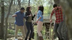 Group of friends dance on outdoor stage in scenic riverside park Stock Footage