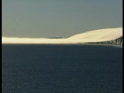 WA katabatic winds blowing snow off ice shelf into sea, Antarctica Stock Footage