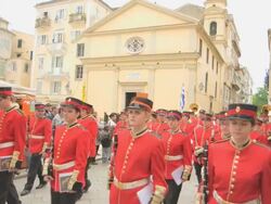 MS Shot of red band pass by holy temple of Yperagia Theotokos (Virgin Mary) in easter parade AUDIO / Kerkyra, Corfu, Greece Stock Footage