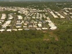 Aerial over wooded wetlands to reveal human settlement Stock Footage