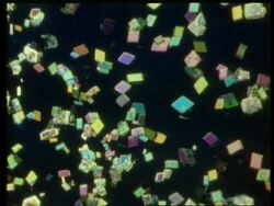 Rotation and zoom into different coloured diamond shaped crystals against black Stock Footage