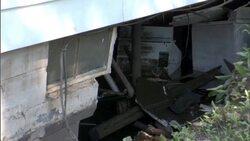Appliances and debris are visible through a washed out wall in a flood damaged building. Stock Footage