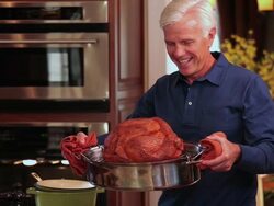 MS TU PAN Senior couple preparing dinner in home kitchen and man taking Turkey out of oven / Richmond, Virginia, United Sates Stock Footage