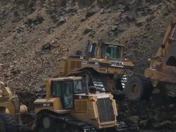 Caterpillar construction vehicles excavate a building site Stock Footage