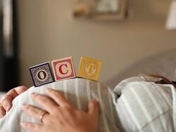 A pregnant women using blocks to spell the month of OCT on her stomach. Stock Footage