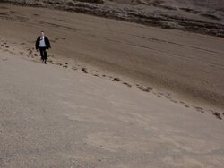 MS Young businessman dressed in  black suit walking on  sand dune in  rural area / Maple Grove, Minnesota, United States Stock Footage