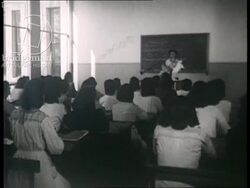 Girls in a Geography lesson, learning how to take care of babies, and doing housework. France 1942 Stock Footage