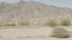 Friends in red convertible speed down desert highway with hands in the air Stock Footage