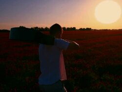 Man with a guitar walking in the sunset Stock Footage