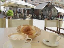 MS Cappuccino coffee and croissant on table at market place / Pietrasanta, Tuscany, Italy Stock Footage