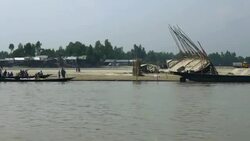 View from a speedboat in the Bangladesh delta as it passes traditional wooden craft moored at the riverbank The receding flood waters leaves bare expanses of soil Stock Footage