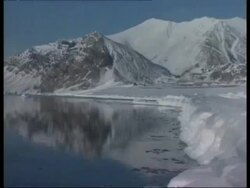 WA Rugged snow covered mountains reflected in foreground water, Arctic circle Stock Footage