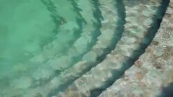 Water ripples on green mosiac tiled of swimming pool steps. View from above Stock Footage