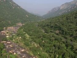 WS AERIAL View of flowing river that runs parallel road / Nelspruit, Mpumalanga, South Africa Stock Footage