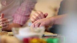 Man cuts strip out of pie dough, woman arranges strip on lattice-top pie Stock Footage