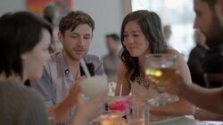 Friends dining in restaurant look at funny photos on smartphone Stock Footage
