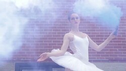 Young ballerina with powder cannon in urban alley Stock Footage