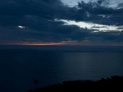 WS T/L Clouds moving across sky and sunset in horizon over ocean at day to night / Big Sur, California, United States Stock Footage