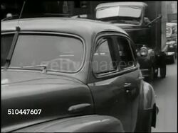 1949: NEW YORK CITY TRAFFIC: WS NYC street, cars, trucks, traffic, pedestrians, stores. VS Vehicles in traffic. MS Male driver w/ cigarette in mouth exits car to look at traffic jam. (POV behind) WS Traffic, congestion. MS Man throws cigarette down. Instructional Video