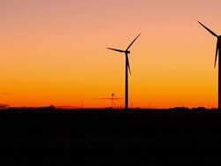 Two Silhouetted Wind Turbines With Windmill Stock Footage