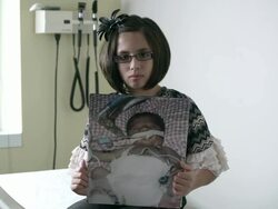 Slow motion of young girl holding up photo of herself when she was a baby in the hospital. Stock Footage