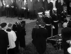 B/W 1963 REAR VIEW Jacqueline, Robert + Edward Kennedy lighting eternal flame at JFK's burial Stock Footage