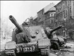 B/W 1956 low angle 2 battered tanks in city street  / Hungarian uprising Stock Footage