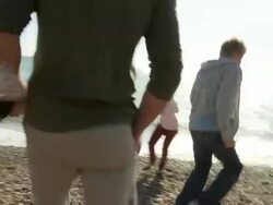 MS, Family with two children (10-11, 12-13) playing on Brighton beach, rear view, Brighton, Sussex, United Kingdom Stock Footage