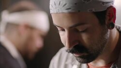 Restaurant cook stares down at prep table while chopping vegetables in kitchen Stock Footage