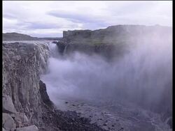 Iceland, MS waterfall cascading into ravine below, steam rises up from base of waterfall Stock Footage