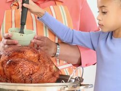 MS TD Grandmother and Granddaughter Cooking Turkey in Kitchen / Richmond, Virginia, USA Stock Footage