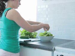 Female preparing salad in kitchen Stock Footage
