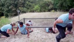 Man and woman helping teammates finish low crawl on boot camp obstacle course Stock Footage