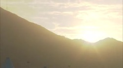 The sun rises in a golden sky above Saudi Arabian mountains. Stock Footage