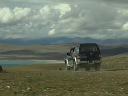 Mid shot Passing car Mansarovar Lake Tibet China Stock Footage