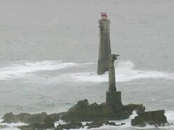 MS AERIAL Shot of Isle de Sein lighthouse off Le Conquet and waves crashing on rocks / Brittany, France Stock Footage