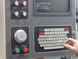 ECU of keyboard and computer screen display of industrial milling machine being manually programmed for metal grinding job / Redlands, California, USA Stock Footage