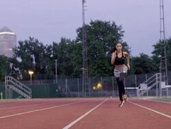 WS to MS female athlete running on track to camera  Stock Footage