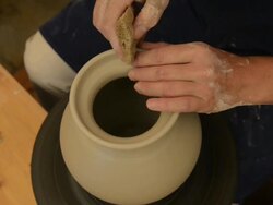 CU Shot of female potter finishing shaping pitcher on potterwheel at pottery / Landshut, Bavaria, Germany Stock Footage