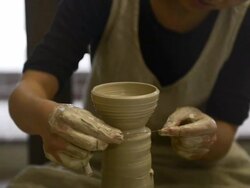 MS Shot of female potter shaping  pot from lump of clay on potters wheel at pottery / Kyoto, Japan Stock Footage
