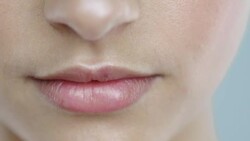 Extreme close-up of young womans lips drinking a glass of water and smiling Stock Footage