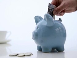 Twenty pound note being placed in to Piggy bank. Stock Footage