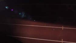 A track athlete passes a baton to his teammate during a relay race. Stock Footage