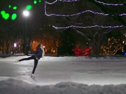 Caucasian female teenager skates with joy on a snowy night.. Stock Footage