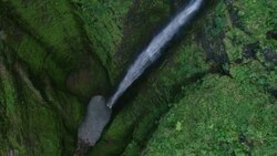 Aerial shot zooming out from the pool at the bottom of Sacred Falls, to the keyhole at the top of the 90 foot waterfall. Stock Footage